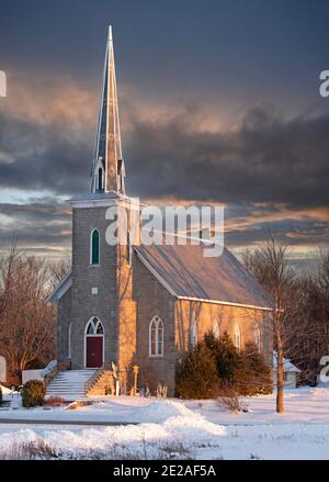 Vecchia chiesa in pietra al tramonto in una fredda giornata invernale Nelle zone rurali del Canada Foto Stock