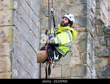 Stonemason James Preston da SSH Conservation, ascili da Rievaulx Abbey nel Nord Yorkshire come l'inglese Heritage si prepara a svolgere vitale lavoro di conservazione. English Heritage commissiona un'indagine all'abbazia di Rievaulx su un ciclo di cinque anni per valutare la condizione dell'abbazia dal piano terra fino alla cima della struttura. Foto Stock