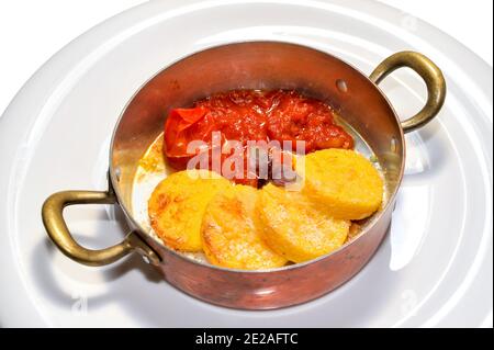 Gnocchi alla romana con salsa di pomodoro in pentole di rame uno sfondo bianco Foto Stock