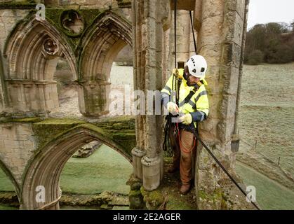 Stonemason James Preston da SSH Conservation, Surveys Rievaulx Abbey nel Nord Yorkshire come English Heritage si prepara a svolgere vitale lavoro di conservazione. English Heritage commissiona un'indagine all'abbazia di Rievaulx su un ciclo di cinque anni per valutare la condizione dell'abbazia dal piano terra fino alla cima della struttura. Foto Stock