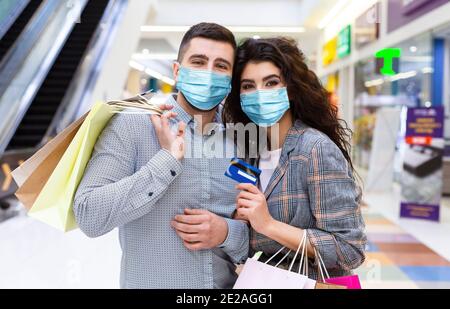 Coppia innamorata con carta di credito e borse per la spesa Foto Stock