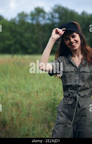 Donna in tuta verde sorridente sul campo Foto Stock