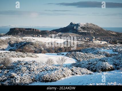 Arthurs Seat e Salisbury Crags Edimburgo in inverno neve on una giornata di sole Foto Stock