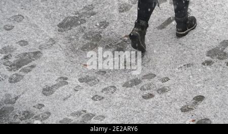 Amburgo, Germania. 13 gennaio 2021. Le stampe delle scarpe possono essere viste sulla neve su un marciapiede. Credit: Marco Brandt/dpa/Alamy Live News Foto Stock