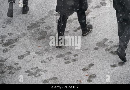 Amburgo, Germania. 13 gennaio 2021. Le stampe delle scarpe possono essere viste sulla neve su un marciapiede. Credit: Marco Brandt/dpa/Alamy Live News Foto Stock