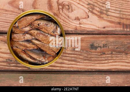 Spratti in una latta su una superficie di legno Foto Stock