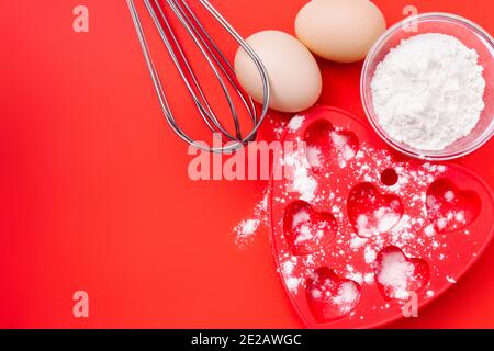 Farina di grano, teglia da forno e frusta per la colazione. San Valentino. Foto Stock