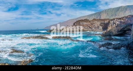 Splendido scenario di un mare circondato da scogliere rocciose sotto un cielo nuvoloso Foto Stock