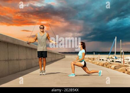 Coppia felice in fase di riscaldamento sul molo prima di partecipare al corso di formazione Foto Stock