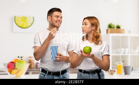 si accoppia in t-shirt bianche con popcorn e mela Foto Stock