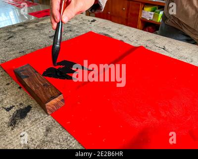 Un calligrafo sta creando e scrivendo i couplets del festival di primavera, il festival cinese di primavera di Capodanno Foto Stock