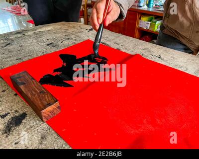 Un calligrafo sta creando e scrivendo i couplets del festival di primavera, il festival cinese di primavera di Capodanno Foto Stock