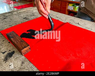 Un calligrafo sta creando e scrivendo i couplets del festival di primavera, il festival cinese di primavera di Capodanno Foto Stock