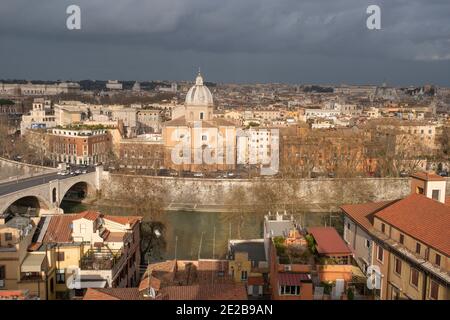 Vista del centro di Roma, Italia, sui tetti di Trastevere fino al Tevere e ai ponti. Chiesa di San Giovanni dei Battisti sulla riva del fiume. Foto Stock