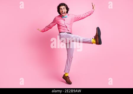 Foto a lunghezza intera di divertente e affascinante brunet pelo uomo danzare salto isolato sfondo di colore rosa Foto Stock