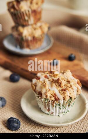 Una foto verticale di deliziosi muffin al mirtillo vegano su un decorato tabella Foto Stock