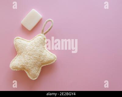 Spugna eco per corpo e sapone bianco su sfondo rosa Foto Stock