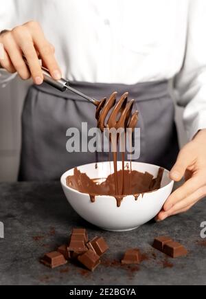 Giovane donna che fa tartufo al cioccolato. Sfondo scuro. Concetto di cibo delizioso. Ottimo design per qualsiasi scopo. Foto Stock