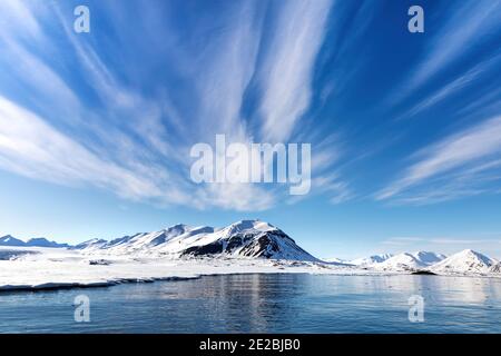 Cielo blu, mare e montagne innevate nei bellissimi fiordi di Svalbard, un arcipelago norvegese tra la Norvegia continentale e il Polo Nord Foto Stock