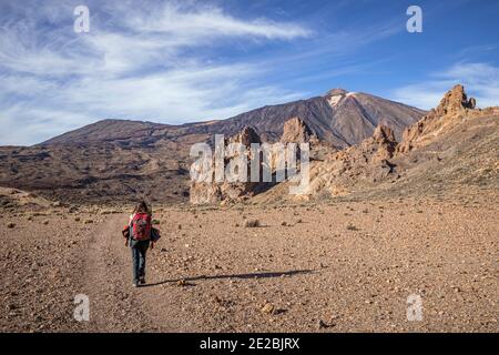 Donna escursionista a piedi verso il Monte Teide / El Teide / Pico del Teide, vulcano nel Parco Nazionale del Teide a Tenerife, nelle Isole Canarie, Spagna Foto Stock