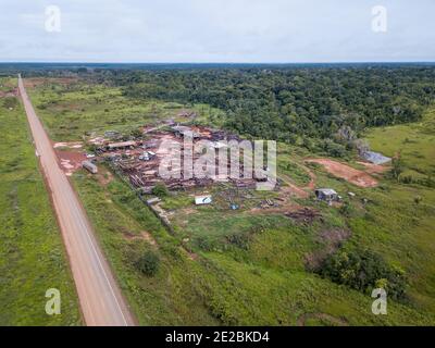 Drone vista aerea di segheria di legname pieno di tronchi in BR 319 strada, Amazzonia foresta pluviale, Brasile. Concetto di ecologia, conservazione, deforestazione, co2. Foto Stock