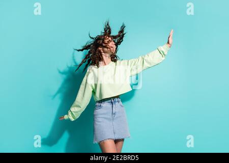 Ritratto fotografico di donna che fa piano con le mani che danzano i capelli volo isolato su uno sfondo di colore ciano brillante Foto Stock