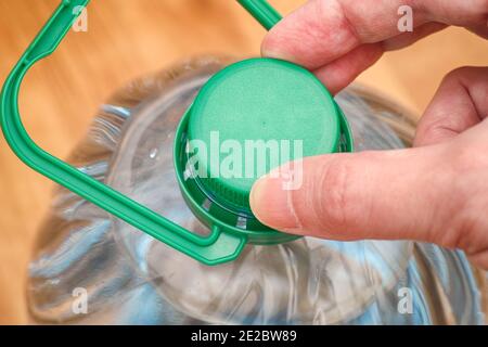 Persona che apre una bottiglia d'acqua. Primo piano. Foto Stock