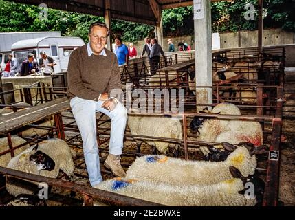 HERTFORD - INGHILTERRA 1986. Frederick McCarthy Forsyth (romanziere) in posa per la macchina fotografica durante la visita Hertford mercato delle pecore e del bestiame nel 1986. Foto di G Foto Stock