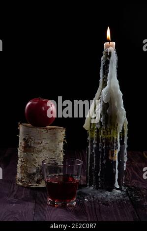 Una candela estinta su una bottiglia di vino con un Apple Foto Stock