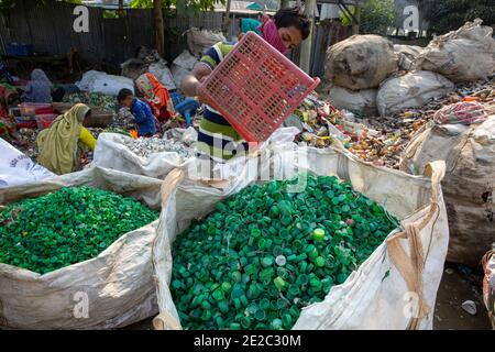 Donne e bambini lavorano in un centro di riciclaggio della plastica a Brahmanbaria, Bangladesh. Foto Stock