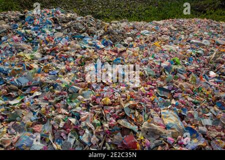 Diverse etichette di bottiglie per animali da compagnia scaricate accanto a un centro di riciclaggio di plastica a Brahmanbaria, Bangladesh. Foto Stock