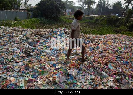 Diverse etichette di bottiglie per animali da compagnia scaricate accanto a un centro di riciclaggio di plastica a Brahmanbaria, Bangladesh. Foto Stock