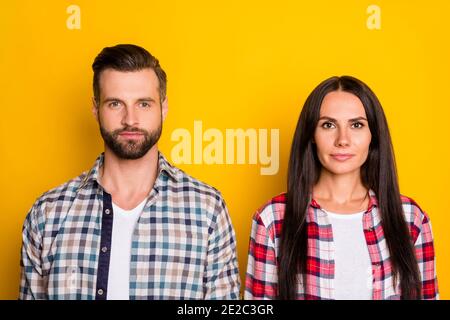 Ritratto di due persone con contenuti interessanti che indossano camicie controllate isolato su sfondo giallo brillante Foto Stock