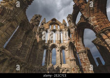 Le storiche rovine del VII secolo dell'Abbazia di Whitby arroccate sulla cima di East Cliff che si affaccia sul Mare del Nord nel nord dello Yorkshire. Foto Stock