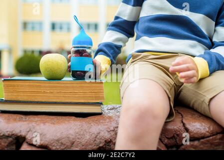 Ora di pranzo a School.A ragazzo nel cortile mangia frutta fresca e verdura. Cambio di all'aperto. Foto Stock