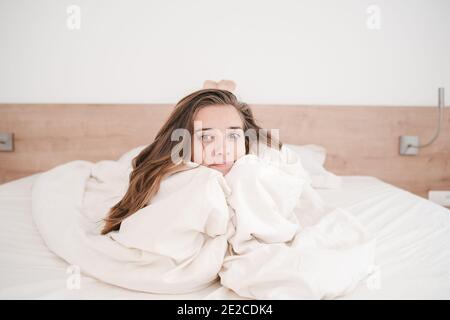 La ragazza è a letto al mattino, gioisce a svegliarsi con una buona mood.Young donna svegliarsi felicemente, dopo una buona notte di sonno Foto Stock