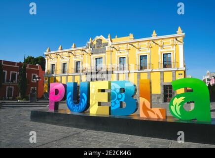 Vista panoramica del Teatro Principal e del colorato segno della lettera della città in primo piano a Zócalo, la piazza principale di Puebla de Zaragoza in Messico. Foto Stock