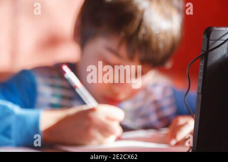 Home formazione online, un ragazzo che utilizza un telefono cellulare e cuffie è impegnato in lingua inglese Foto Stock