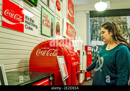 Una donna ispeziona un'antica macchina Coca-Cola mentre cammina attraverso il Coca-Cola Museum a Corinth, Mississippi, 5 marzo 2012. Foto Stock