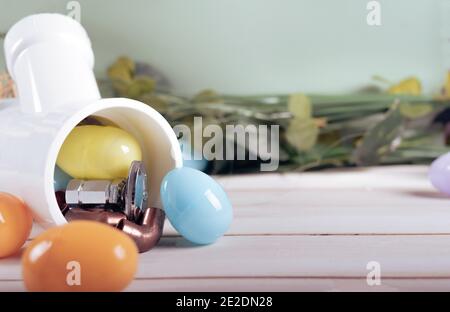 Strumenti per l'uovo di Pasqua e l'idraulica, tubi e raccordi in rame. Plumber vacanze. Spazio per la copia. Foto Stock