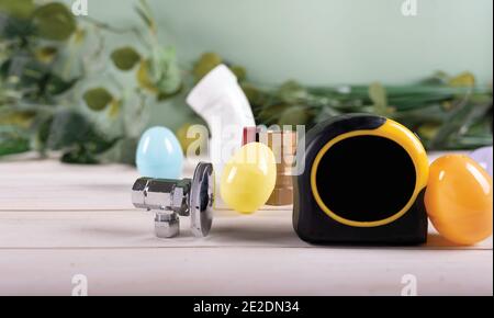 Strumenti per l'uovo di Pasqua e l'idraulica, tubi e raccordi in rame. Plumber vacanze. Spazio per la copia. Foto Stock