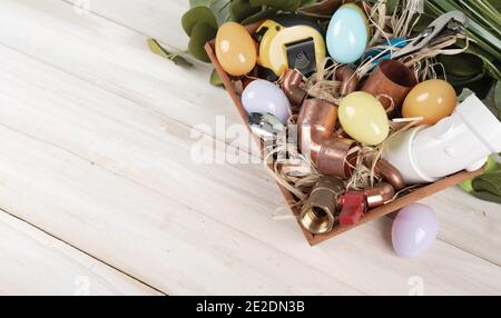 Strumenti per l'uovo di Pasqua e l'idraulica, tubi e raccordi in rame. Idraulico per le vacanze. Vista dall'alto. Spazio di copia. Foto Stock