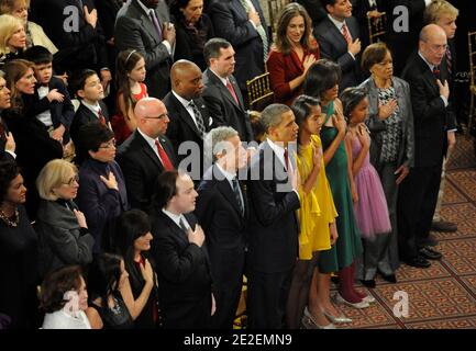 Il presidente DEGLI STATI UNITI Barack Obama, la prima signora Michelle Obama e le figlie Malia e Sasha si uniscono al pubblico nella riproduzione dell'inno nazionale prima di assistere agli spettacoli del gala annuale 'Christmas in Washington' tenutosi presso il National Building Museum di Washington, D.C., USA il 11 dicembre 2011. Festeggiando il suo trentesimo anniversario quest'anno, il Natale a Washington è una tradizione di vacanza che avvantaggerà il Children's National Medical Center. Foto di Mike Theiler/Pool/ABACAPRESS.COM Foto Stock