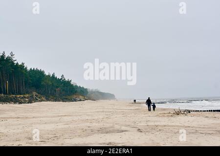 Foto di persone che camminano lungo la riva del Mar Baltico in autunno, Sarbinowo, Polonia Foto Stock