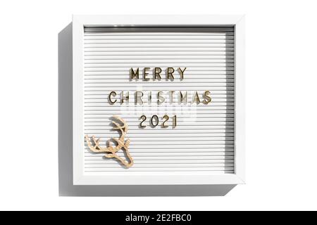 Cartellone con auguri di buon Natale 2021, citazione di saluto sulla lavagna a lettere su sfondo bianco. Posa piatta, dall'alto Foto Stock