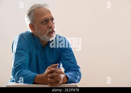 UN UOMO ADULTO ANZIANO CHE GUARDA VIA E PENSA Foto Stock