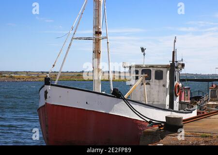 Piccola barca da pesca con casetta ormeggiata al molo nella stazione di pesca. Foto Stock