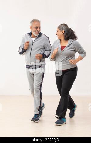 UNA COPPIA FELICE CHE SI GUARDA L'UN L'ALTRO MENTRE SI FA JOGGING Foto Stock