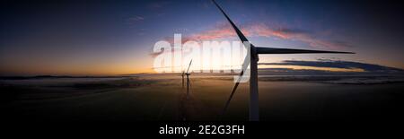 Vista aerea di tre turbine eoliche al mattino presto Nebbia all'alba nella campagna inglese panoramica Foto Stock