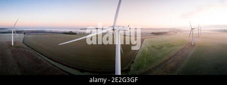 Vista aerea di tre turbine eoliche al mattino presto Nebbia all'alba nella campagna inglese panoramica Foto Stock